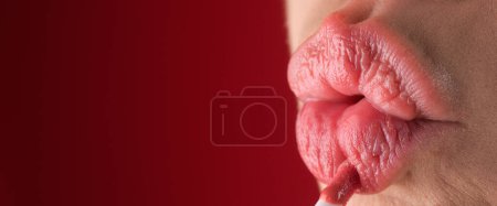 Téléchargez les photos : Appliquer du rouge à lèvres, macro. Peindre les lèvres avec du rouge à lèvres brillant, fermer. choyer, concept de correction des lèvres. Rouge à lèvres brillant sur lèvre pleine dodue. Femme main appliquant rouge à lèvres. Baume à lèvres - en image libre de droit