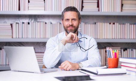 Photo for Portrait of teacher with book in library classroom. Handsome teacher in university. Teachers Day. Good school teacher. Tutor at college. Man with books in library. Knowledge and education concept - Royalty Free Image