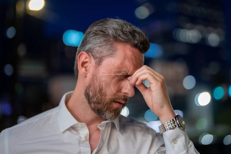 Photo for Close up portrait of stressed business man on nicht city background. Stressed ceo manager have stress and headache migraine outdoor. Tired freelancer man in night street. Tired business overworked man - Royalty Free Image