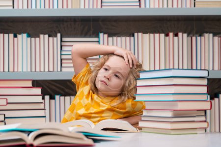 Photo for Back to school. Kid on school library. Child reading book at school. Nerd pupil studying in classroom. Clever intelligent schoolboy overwork. Smart child learning to read book. Hard study - Royalty Free Image