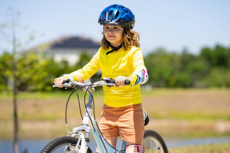 Photo for Child riding bicycle. Little kid boy in helmet on bicycle along bikeway. Happy cute little boy riding bicycle in summer park. Child in protective helmet for bike cycling on bicycle. Kid riding bike - Royalty Free Image