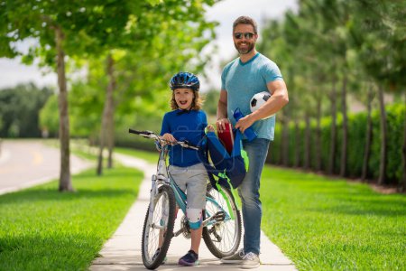 Photo for Father helping son get ready for school. Father teaching son riding bike. Fatherhood. Support parent. Fathers day. Child care. Fathers day - Royalty Free Image