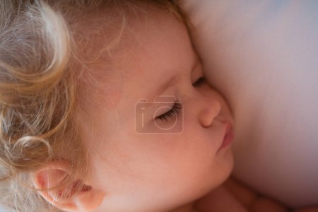 Téléchargez les photos : Gros plan du bébé qui dort dans son lit. Portrait d'enfant endormi - en image libre de droit
