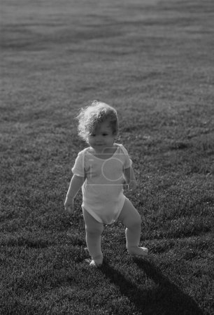 Photo for Beautiful baby walking in the park in diaper pants - Royalty Free Image