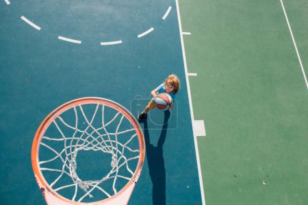 Téléchargez les photos : Un gamin qui joue au basket. Mode de vie sportif des enfants. Activité sportive pour enfants - en image libre de droit