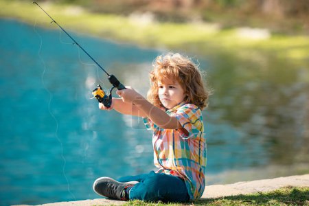 Foto de Feliz pesca infantil. Chico con spinner en el río. Concepto de pesca - Imagen libre de derechos