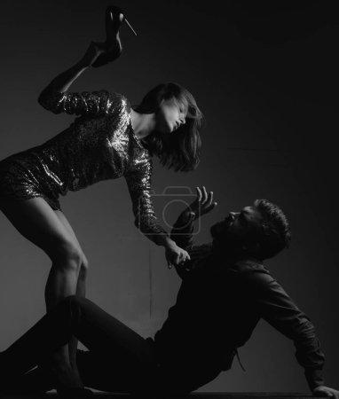 Foto de Víctimas masculinas de agresión sexual. Una mujer atractiva está golpeando a un hombre con tacones - Imagen libre de derechos