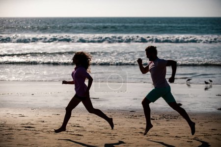 Photo for Couple running on beach. Sport and healthy lifestyle, silhouette friends jogging at sunset on the beach - Royalty Free Image