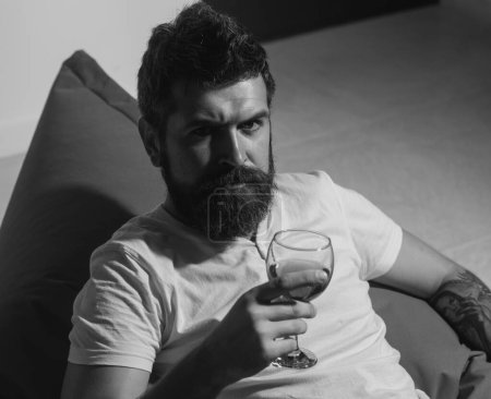 Foto de Beber solo. Adicción al alcohol. Un hombre serio con una copa de vino. Retrato casual hipster - Imagen libre de derechos