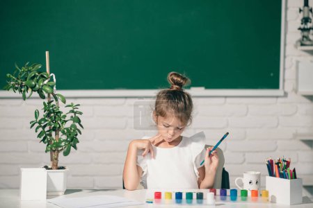 Foto de Little girls drawing a colorful pictures with pencil crayons in school classroom. Kids creative growth - Imagen libre de derechos