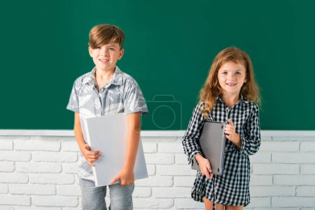 Photo for Back to school. Cute little children girl and boy studying in classroom at elementary school - Royalty Free Image