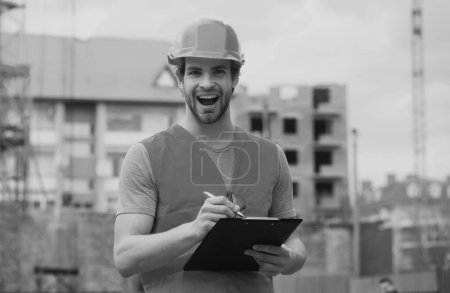 Foto de Retrato de constructor de construcción. Obrero de la construcción con ropa de trabajo y casco de construcción - Imagen libre de derechos
