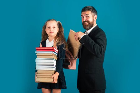 Photo for Pupil girl with pile of books ready to school. Hard to study. Father preparing backpack with school supplies for daughter - Royalty Free Image