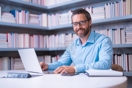 Photo for Portrait of teacher with book in library classroom. Handsome teacher in university. Teachers Day. Good school teacher. Tutor at college. Man with books in library. Knowledge and education concept - Royalty Free Image