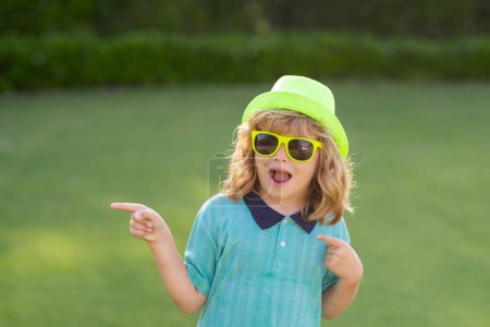 Photo for Kid point finger. Portrait of kid in spring park outdoors. Close-up face child playing outdoors in summer park - Royalty Free Image