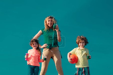 Foto de Deporte saludable estilo de vida familiar. Familia feliz Madre e hijo de pie sobre el fondo del cielo. Madre, hija e hijo miking sport - Imagen libre de derechos