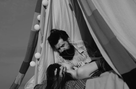 Photo for Couple in a tent. Sensual portrait of young couple in love camping. Loving couple embracing and kissing - Royalty Free Image