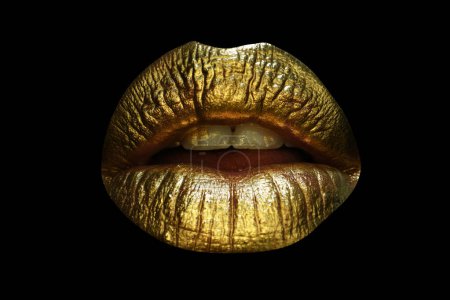 Foto de Primeros planos de labios rellenos femeninos con maquillaje de color oro. Cosmética de brillo dorado. Brillante estilo navideño para labios sexys. Labios dorados glamour. Aislado en negro - Imagen libre de derechos