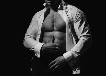 Foto de Hombre musculoso mostrando su pecho durante el striptease. Torso de hombre. Un chico guapo posando. Retrato de moda del deportista sano musculoso fuerte. Torso sexy. Modelo masculino sin camisa - Imagen libre de derechos