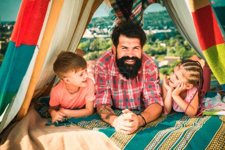 Foto de Día de los Padres. Camping familiar. Concepto de vacaciones al aire libre. Padre feliz con campamento de niños - Imagen libre de derechos