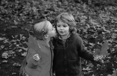 Téléchargez les photos : Adorable garçon et fille étreignant dans le parc d'automne - en image libre de droit