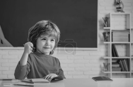 Photo for Children learning. Cute child boy in classroom near blackboard desk. Chalkboard copy space. School education and people concept - cute pupil over blackboard background - Royalty Free Image