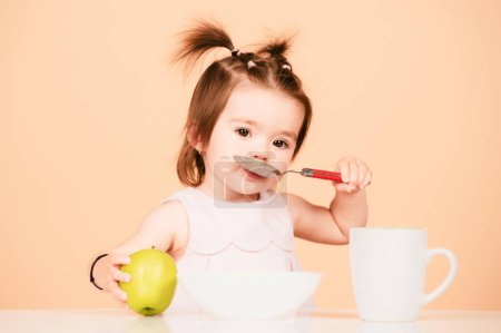 Photo for Cute baby food, babies eating. Kid eating healthy food with a spoon at studio, isolated. Funny kids face - Royalty Free Image