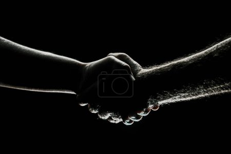 Foto de Un apretón de manos entre los dos socios, acuerdo. Rescate manos masculinas. Un apretón de manos amistoso, saludo de amigos, amistad. Rescate, ayuda gesto o manos. Mano de ayuda - Imagen libre de derechos