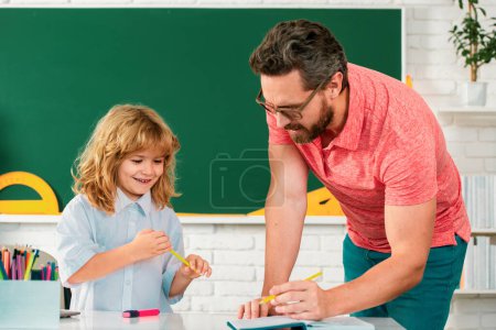 Photo for Father teacher helping a son boy in school lessons. Funny happy elementary school boy - Royalty Free Image