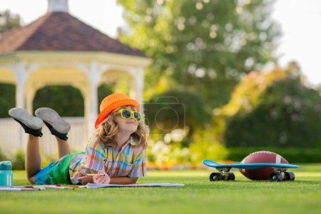 Photo for Child with artwork homework on playground. School kid drawing in summer park, painting art. Little painter draw pictures outdoor. Happy child playing outside. Drawing summer theme - Royalty Free Image