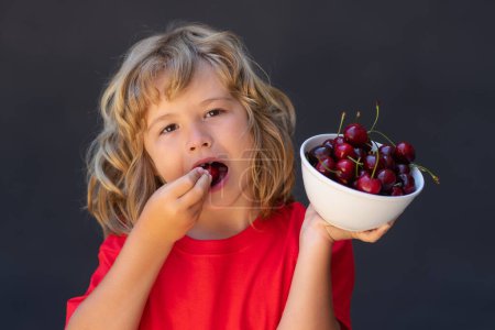 Photo for Kid picking and eating ripe cherries. Happy child holding fresh fruits. Healthy organic berry cherry fruit, summer season - Royalty Free Image