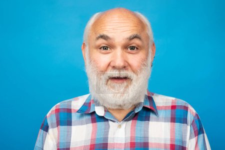 Foto de Hombre maduro sorprendido con barba gris en el fondo del estudio. Retrato de anciano mayor caucásico anciano - Imagen libre de derechos