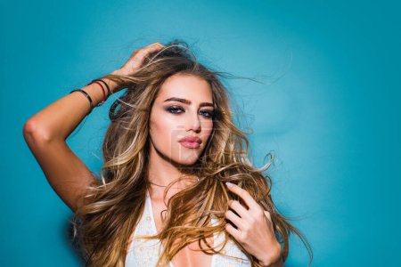 Photo for High fashion model girl posing in studio. Beautiful fashion woman looking at camera. Blond woman with long curly beautiful hair. Clean skin. Portrait of a young blond woman with long healthy hair - Royalty Free Image