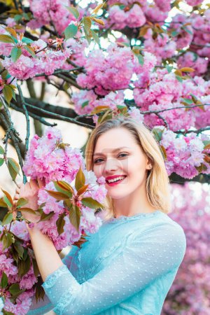 Photo for Womens day, 8 march. Beautiful woman with blooming Sakura tree and sunny day - Royalty Free Image