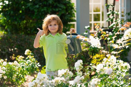 Téléchargez les photos : Enfant arrosant une plante avec arrosoir - en image libre de droit