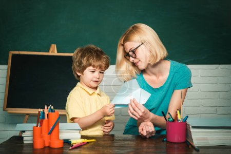 Photo for Back to school and Education concept. Teacher helping young boy with lesson. Child from elementary school with book - Royalty Free Image