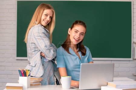 Photo for Students girls talking each other in classroom at school college. Learning and preparing for exam with friends - Royalty Free Image
