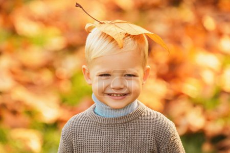 Foto de Adorables niños de otoño con hojas en el parque de belleza. Sonríe cara de niños - Imagen libre de derechos