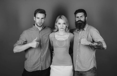 Photo for Love triangle concept. Blonde girl and two guys in casual clothes looking at the camera - Royalty Free Image