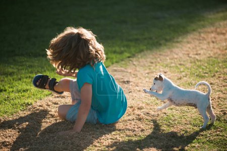 Téléchargez les photos : Jeu de chien drôle. Enfant garçon jouissant avec son meilleur chien ami. Enfants jouant avec son chien de compagnie - en image libre de droit