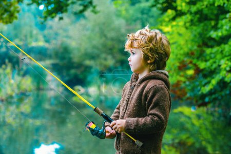 Téléchargez les photos : Portrait d'enfant mignon petit garçon pêche. Enfant avec bobine tournante - en image libre de droit