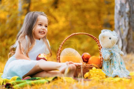 Téléchargez les photos : Gros plan d'enfants cueillant et mangeant des pommes rouges à la ferme biologique, à l'automne à l'extérieur. Feuilles tombant - en image libre de droit
