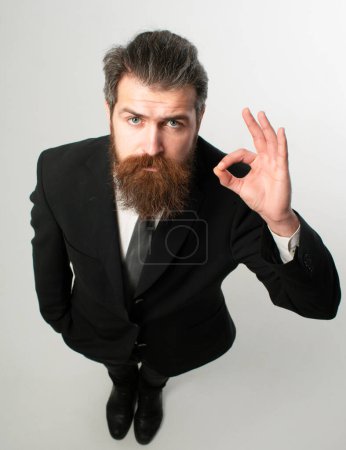 Téléchargez les photos : Bel homme d'affaires drôle en costume avec ok signe grand angle. Gestion d'entreprise. Grande idée - en image libre de droit