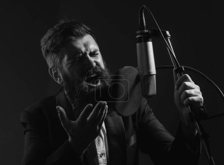 Téléchargez les photos : Singer interprète une chanson tout en enregistrant dans un studio de musique - en image libre de droit