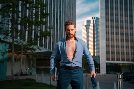 Photo for Caucasian business man in suit comes out office. concept of end working day. Sexy fashion businessman in open shirt - Royalty Free Image