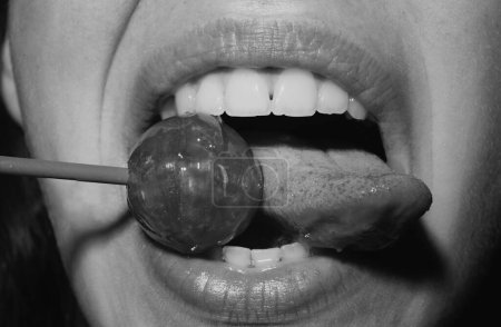 Foto de Licking tongue lips. Sexual lips with candy, sexy sweet dreams. Female mouth licks chupa chups, sucks lollipop - Imagen libre de derechos