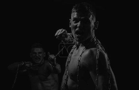 Foto de Batalla de hombres. Músculos torácicos. Torso masculino. Hombres con cadenas rotas, sujetando cadenas. Chicos musculosos - Imagen libre de derechos