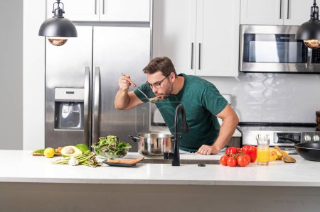 Photo for Male cook or chef cooking food in pan pot in kitchen. Process of preparing gourmet dish. Man cooking at home in kitchen, using pot. Chef cooking food. Handsome chef cook cooking concept - Royalty Free Image
