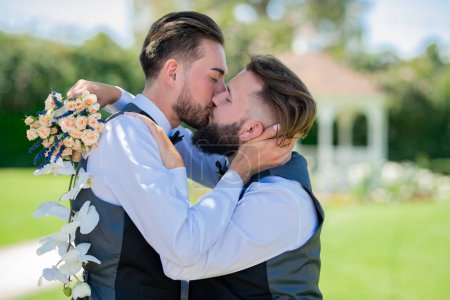 Foto de Retrato de feliz pareja gay enamorada el día de la boda. Beso gay en la boda. Matrimonio pareja gay tierno besos. De cerca retrato de gay besado - Imagen libre de derechos