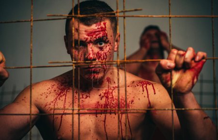 Photo for Psycho mad man. Murderer mythical creature. Halloween concept. Scary monster just murdered his victim. Strong aggressive monster behind grid. Muscular man nude torso soiled blood. Prison for monster. - Royalty Free Image
